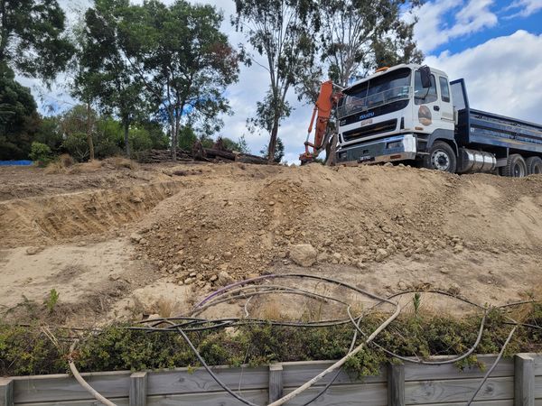 Excavator clearing demolished material from site